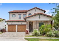 Charming two-story home with a brick driveway, two-car garage, tile roof, and well-maintained landscaping at 8210 Topsail Pl, Winter Garden, FL 34787