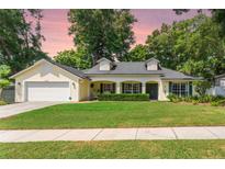 Charming single-story home with a manicured lawn, attached garage, and welcoming front porch at 1018 Featherstone Cir, Ocoee, FL 34761