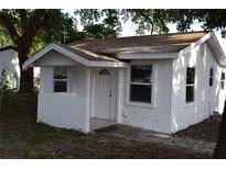 Charming single-story home featuring white stucco and a welcoming covered porch, perfect for enjoying quiet moments at 1518 Indiana St, Orlando, FL 32805