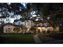 Stunning Mediterranean-style home with lush landscaping, mature trees, and a grand entrance at 1716 Greystone Ct, Longwood, FL 32779