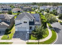 Beautiful two-story home with solar panels, a paved driveway, and a well-maintained lawn at 1909 Donahue Dr, Ocoee, FL 34761