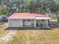 Charming single-story home featuring a red metal roof, a front porch and an attached garage at 288 N Seneca St, Daytona Beach, FL 32114