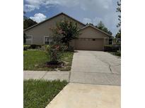 Inviting single-Gathering home featuring a well-manicured lawn and attached two-car garage at 6019 Long Peak Dr, Orlando, FL 32810