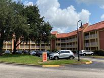 Exterior view of the condo building with balconies, parking lot, and well maintained landscaping at 6403 Parc Corniche Dr # 4308, Orlando, FL 32821