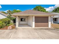 Charming home featuring an attached garage, carport, and inviting front yard landscaping at 720 Lakeside Dr, Winter Springs, FL 32708