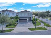 Two story home featuring a neutral color scheme, paved drive and manicured landscaping at 7584 Marker Ave, Kissimmee, FL 34747