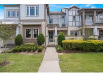 Charming townhome with lush landscaping, and a welcoming walkway leading to the front door at 9255 Doherty Pl, Orlando, FL 32827