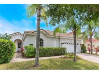 Charming single-story home with lush landscaping, brick driveway, and well-maintained lawn at 11878 Via Lucerna Cir, Windermere, FL 34786