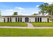 Stunning single story home featuring an arched doorway and manicured front yard landscaping at 2327 Fieldingwood Rd, Maitland, FL 32751