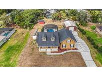 Expansive backyard featuring a screened pool, detached garage, and pristine landscaping at 2420 Heron Ct, St Cloud, FL 34769