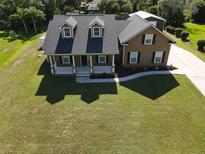 Aerial view of a charming two-story home with a sprawling green lawn and inviting front porch at 2420 Heron Ct, St Cloud, FL 34771