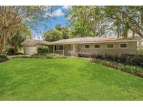 Charming single-story home with manicured lawn, mature landscaping, and attached garage at 3605 Pershing Ave, Orlando, FL 32812
