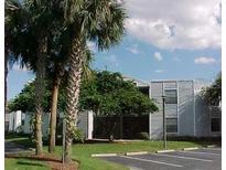 Condo community with mature palm trees and well-maintained landscaping on a sunny day at 3807 Atrium Dr, Orlando, FL 32822
