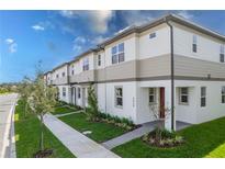 Charming townhome exterior featuring neutral tones, manicured landscaping, and a welcoming walkway to the front door at 4830 Prairie Preserve Run, St Cloud, FL 34772