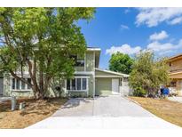 Charming two-story home with green siding, a concrete driveway, and mature trees in the front yard at 522 Boxelder Ave, Altamonte Springs, FL 32714