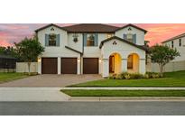 Beautiful two-story home with a three-car garage, arched entryway, and well-maintained lawn at 675 Primrose Willow Way, Apopka, FL 32712