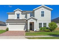 Charming two-story home boasts a well-manicured lawn and an attached two-car garage at 683 Campo Ln, Davenport, FL 33837