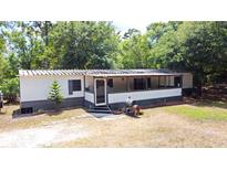 Charming single-story home with a covered porch and lush landscaping at 736 Guy Rd, Orlando, FL 32828