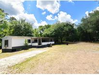 Single-story home featuring a long driveway and a large, tree-filled lot at 736 Guy Rd, Orlando, FL 32828