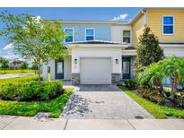 Charming townhome with a two-car garage, stone accents and a well-manicured front yard at 743 Driving Range Ct, Reunion, FL 34747