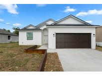 Charming single-story home featuring a white exterior, a two-car garage, and a well-manicured lawn at 9919 Cypress Park Dr, Orlando, FL 32824