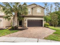 Inviting two-story home with brick driveway, two car garage, and lush landscaping at 1801 Nice Ct, Kissimmee, FL 34747