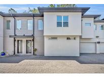 Contemporary townhome featuring a textured gray brick facade and a well-maintained paved driveway at 2162 Lake Howell Preserve Ct, Maitland, FL 32751