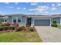 Charming single-story home with well-maintained landscaping and a brick paver driveway at 525 Narrow View Ln, Groveland, FL 34736