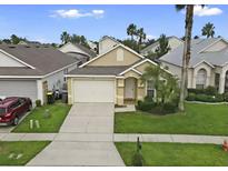 Charming single-Gathering home featuring a two-car garage, landscaped yard, and welcoming front porch at 833 Lockbreeze Dr, Davenport, FL 33897