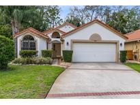 Charming single-story home with a two-car garage, well-maintained landscaping, and a welcoming facade at 912 Augusta National Blvd, Winter Springs, FL 32708