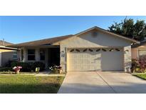 Charming single-story home with a well-manicured lawn, two-car garage and lovely curb appeal on a sunny day at 2244 Silver Lakes N Dr, Lakeland, FL 33810