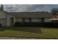 Single-story home featuring brick accents, a well-maintained lawn, and mature landscaping at 2342 Cilantro Dr, Orlando, FL 32837