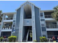 Exterior view of a blue and gray two-story building with an open stairwell and balconies at 2516 Grassy Point Dr # 210, Lake Mary, FL 32746