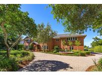 Stately two-story red brick home featuring a circular driveway, fountain and lush landscaping at 2828 Marquesas Ct, Windermere, FL 34786