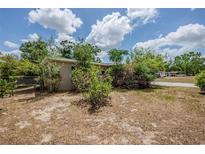 Modest home featuring a neutral-toned exterior and mature landscaping under a partly cloudy sky at 3025 Bon Air Dr, Orlando, FL 32818