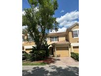 Charming townhome featuring a well-maintained lawn, two-car garage, and classic architectural details at 3567 Shallot Dr # 103, Orlando, FL 32835
