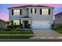 Two-story home with red shutters, manicured lawn, flowerbeds and driveway at 3829 Allegany Ln, Sanford, FL 32771