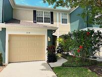 Charming home featuring a one-car garage and beautifully landscaped front yard with vibrant flowers at 5114 Hawkstone Dr, Sanford, FL 32771