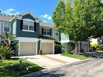 Inviting townhome with a two-car garage, lush landscaping, and a well-maintained driveway at 5114 Hawkstone Dr, Sanford, FL 32771