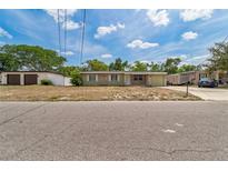 Charming single-story home with stone accents and a well-maintained front yard and one-car garage at 6042 Bolling Dr, Orlando, FL 32808