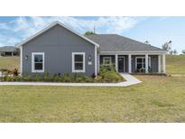 Charming single-story home with a well-manicured lawn and inviting front porch at 72 Fairway Cir, Umatilla, FL 32784