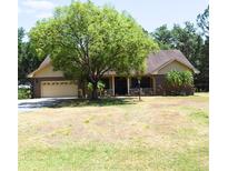 Traditional-style home with a large shade tree and a well-manicured lawn at 859 Morning Star Dr, Lakeland, FL 33810