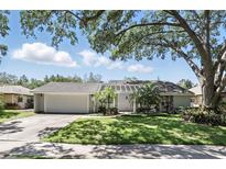 Charming single-story home with a lush green lawn, mature trees, and a two-car garage at 1129 Golfside Dr, Winter Park, FL 32792