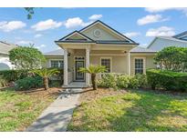 Charming single-story home with a covered porch, columns, green lawn, and manicured landscaping at 12936 Freeman St, Windermere, FL 34786