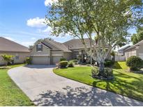 Traditional home featuring well-manicured lawn, mature trees, and three-car garage at 14315 Letham Grange Ct, Orlando, FL 32828