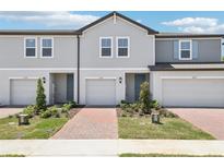 Charming townhomes feature attached garages, neatly landscaped yards and light-colored exterior paint at 16391 Bird Of Paradise Ave, Clermont, FL 34714