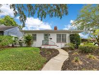 Charming home featuring a curved walkway to the front door, mature landscaping, and a brick facade at 1845 Delaney Ave, Orlando, FL 32806