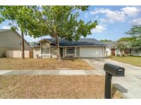 A well-maintained single-story home featuring a tidy front yard and an attached two-car garage at 1993 Excalibur Dr, Orlando, FL 32822
