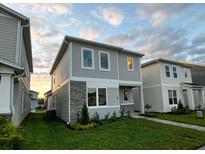 Charming two-story home featuring stone accents and well-manicured landscaping under a beautiful sky at 1999 Iorio St, St Cloud, FL 34771