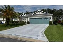 Charming single-story home with a well-manicured lawn and a two-car garage at 24125 Peekskill St, Leesburg, FL 34748